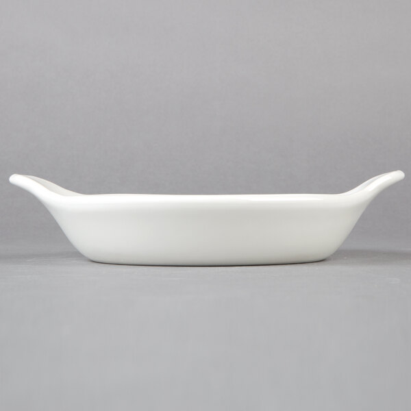 A round white Hall China au gratin dish with a handle.