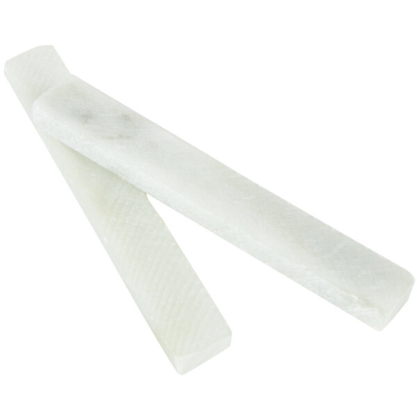 A close-up of a rectangular black slate tray with white soapstone chalk.