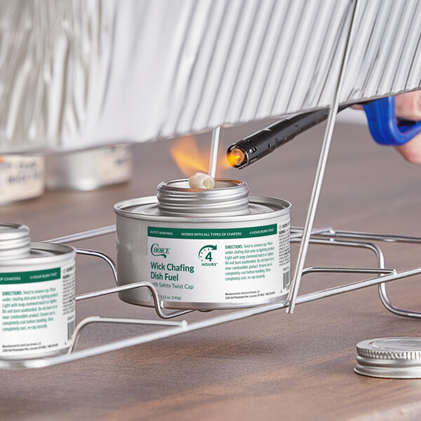 A can of Choice 4 Hour Wick Chafing Dish Fuel with a safety twist cap being lit with a lighter.