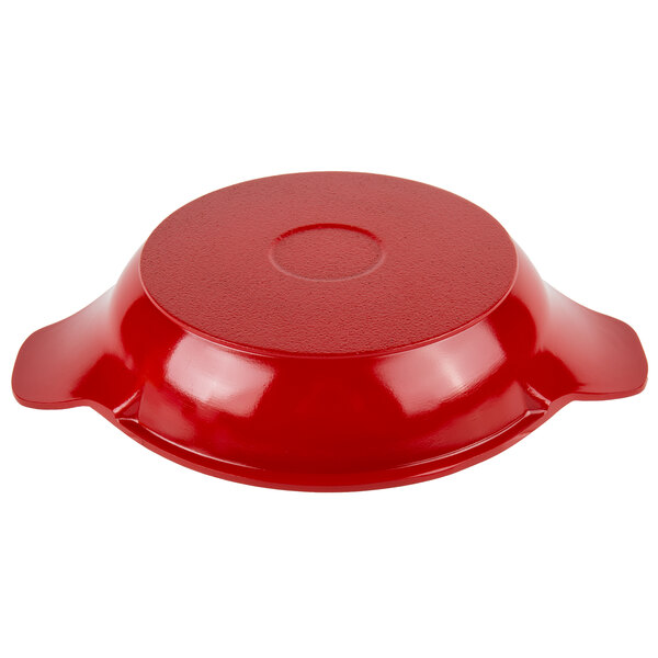 A red and white enamel coated round pan with a handle on top.