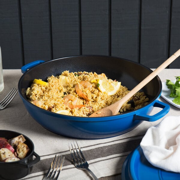 A blue GET enamel coated cast aluminum pan with rice and lemon slices in it.