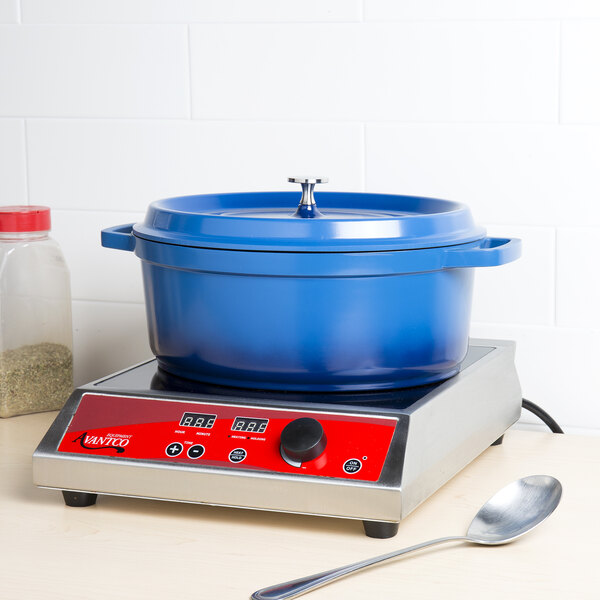 A cobalt blue oval Dutch oven with a lid on a counter.