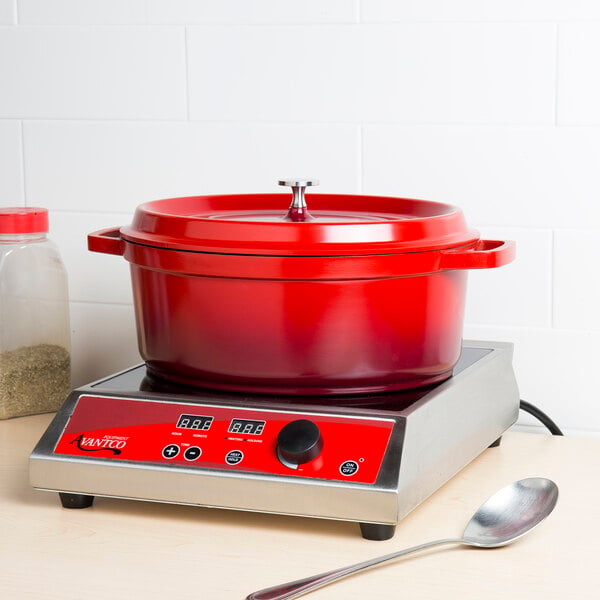 A red pot with a lid on a stove.