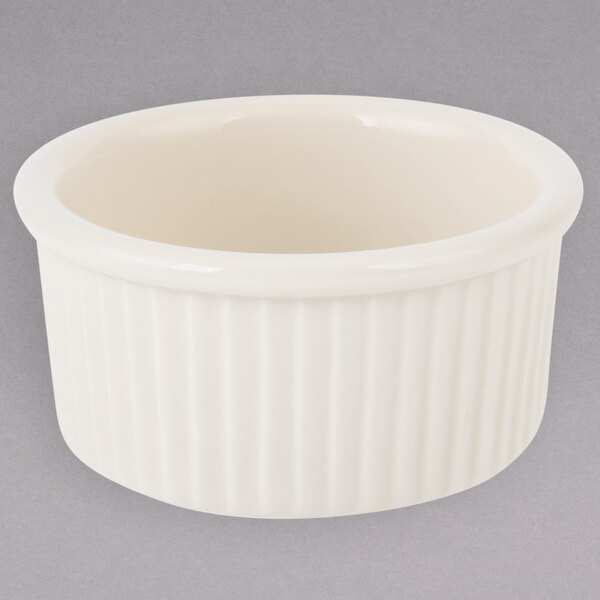A white ceramic Tuxton fluted ramekin with a small white rim.