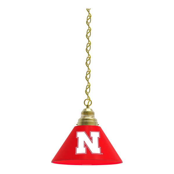 A red pendant light with a brass finish and the University of Nebraska N logo on the shade.