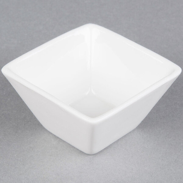 An American Metalcraft white square porcelain sauce cup on a gray surface.