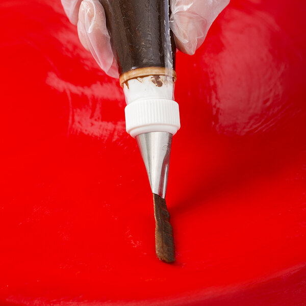 A hand using an Ateco wavy petal piping tip on a pastry bag.