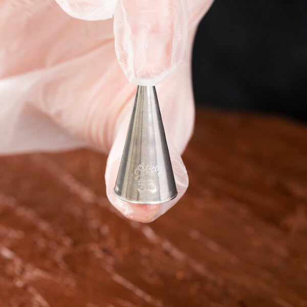 A hand holding an Ateco oval piping tip.