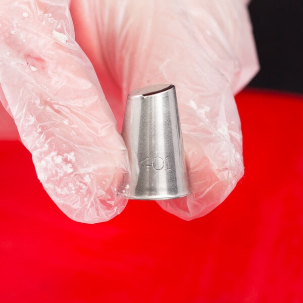 A hand holding a silver metal Ateco U-shape ruffle piping tip.