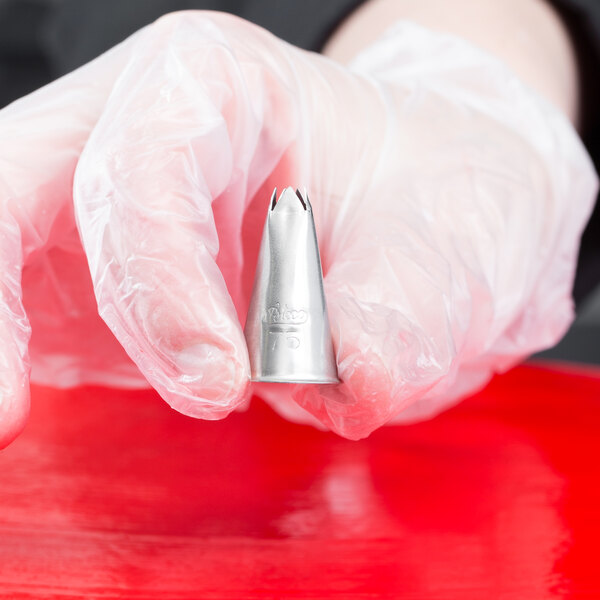 A hand holding an Ateco leaf piping tip.