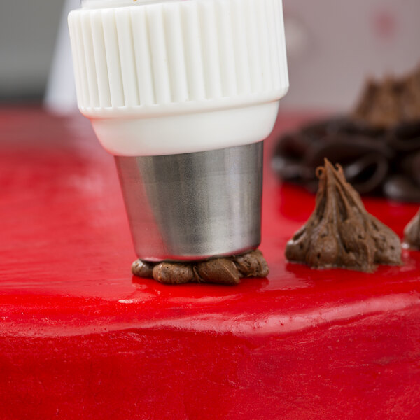 A close up of a white and silver Ateco 254 Russian Piping Tip.