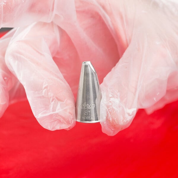 A hand holding an Ateco Lily-of-the-Valley piping tip.