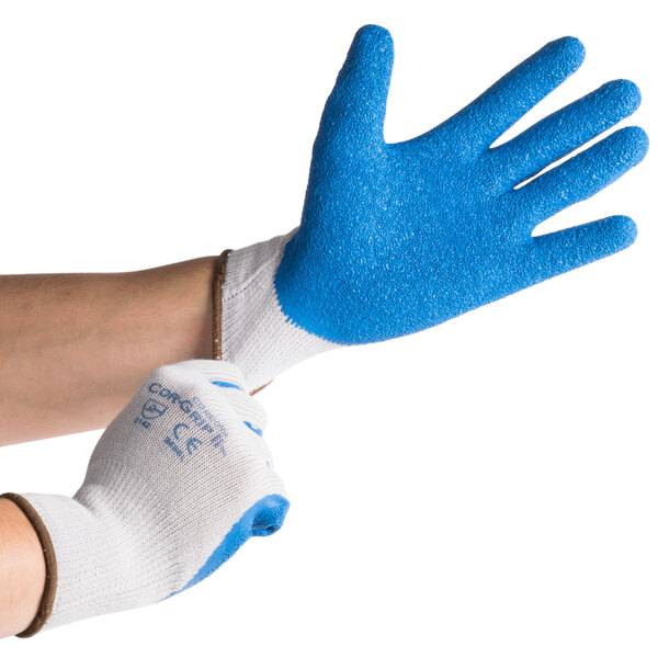 A person wearing Cordova gray gloves with blue latex palms.