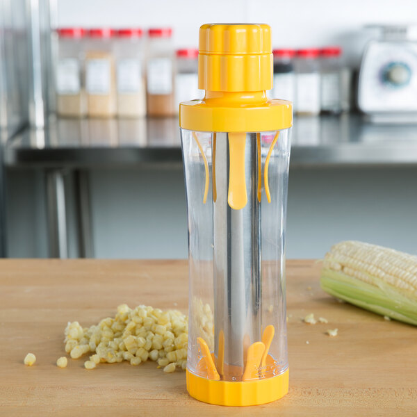 A yellow and clear Weston corn stripper with corn kernels in it.