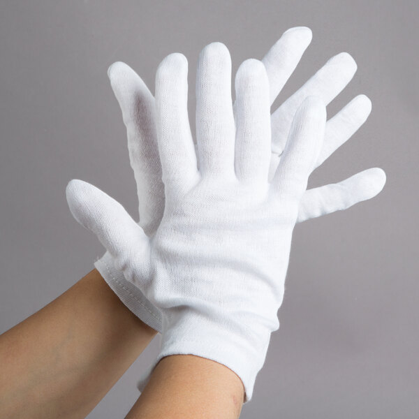 A pair of hands wearing white Cordova inspection gloves.