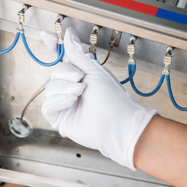 A hand wearing a white Cordova inspector's glove.