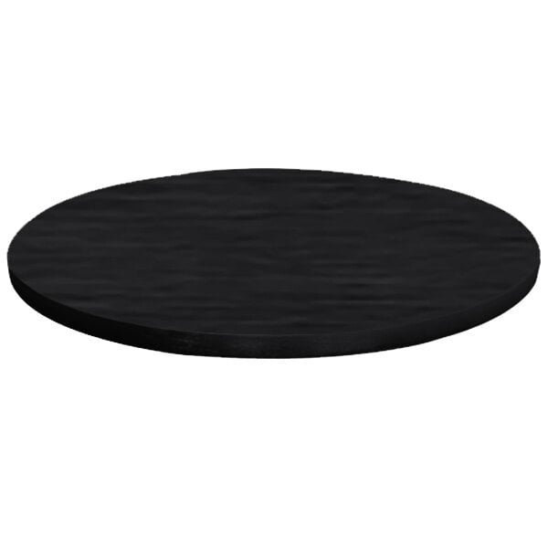 A black circular brushed aluminum table cover on a table with a white background.