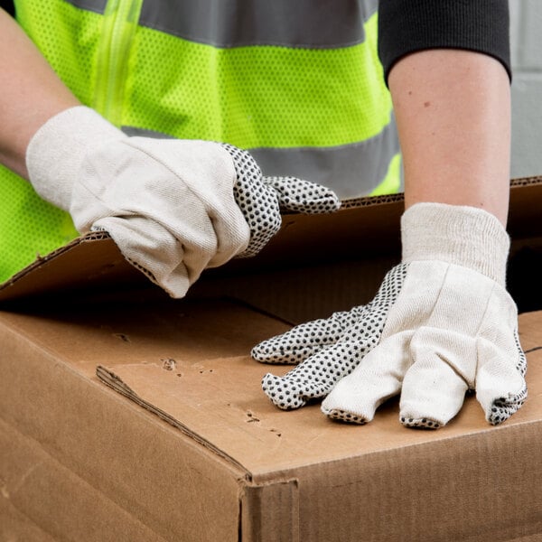 Packer opening a box with warehouse gloves