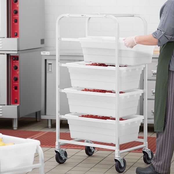 A person pushing a Regency mobile lug rack with containers.