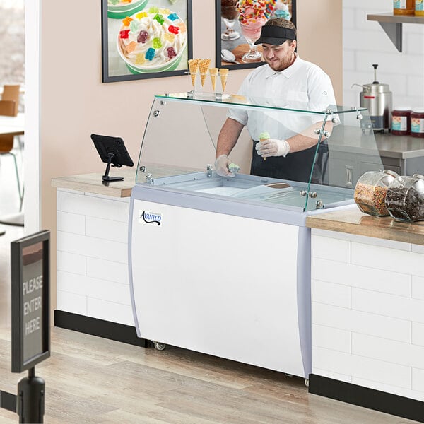Employee scooping ice cream from a dipping cabinet