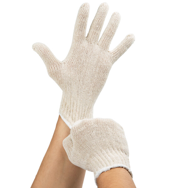 A close-up of a hand wearing a Cordova Economy Weight natural polyester / cotton work glove.