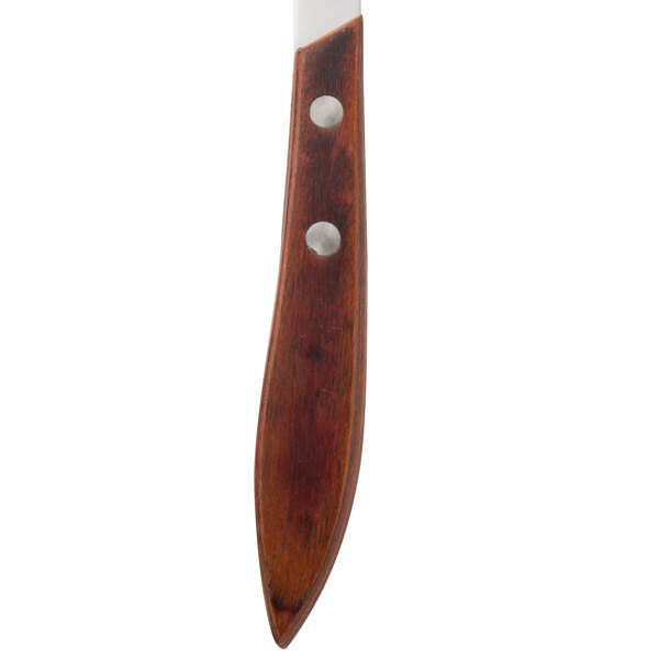 A Walco stainless steel steak knife with a Pakka wood handle.