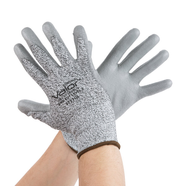 A pair of hands wearing Cordova gray and white gloves.