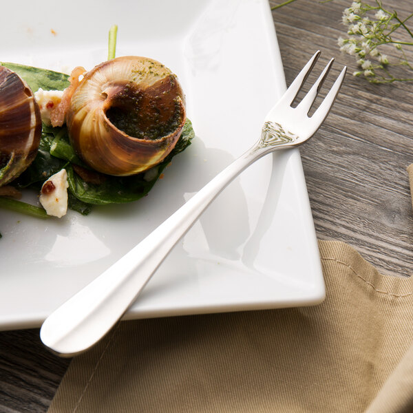 A plate with a Walco cocktail fork and a snail on it.