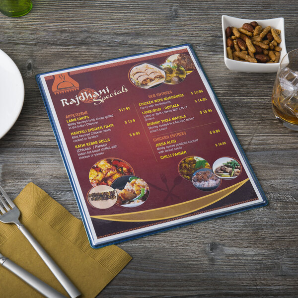 A dark blue Menu Solutions menu board on a table with a fork and knife.