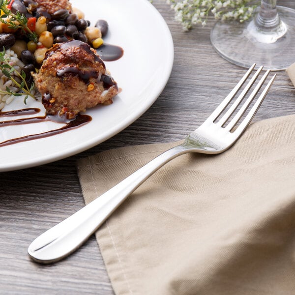 A plate of food with a Walco Lancer dinner fork and a napkin.