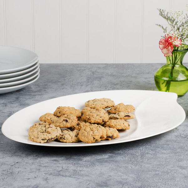 A Villeroy & Boch white porcelain oval platter filled with cookies on a table.