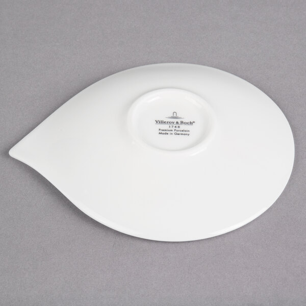 A white Villeroy & Boch porcelain saucer with a small white flower on it.