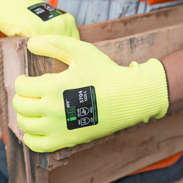 A close-up of a pair of Cordova yellow cut resistant gloves with a yellow polyurethane palm coating.