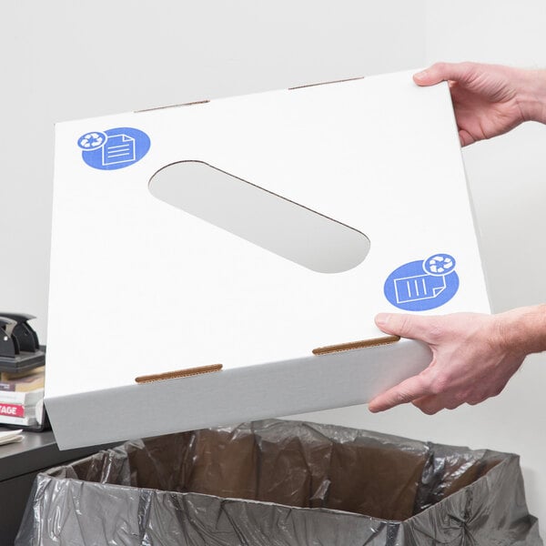 A person holding a white box with a blue sticker.