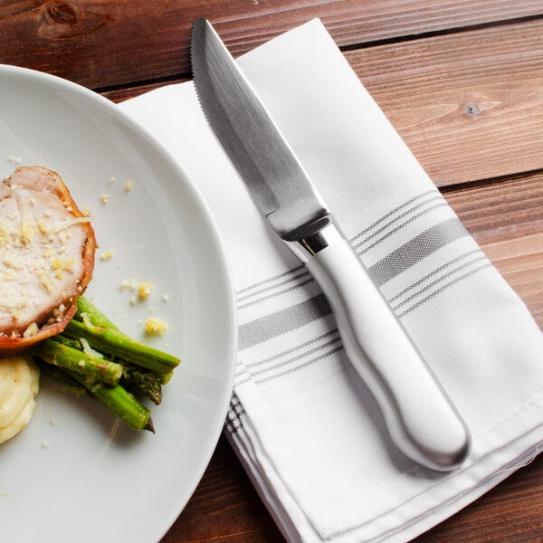 A plate of food with a Walco steak knife on a napkin.