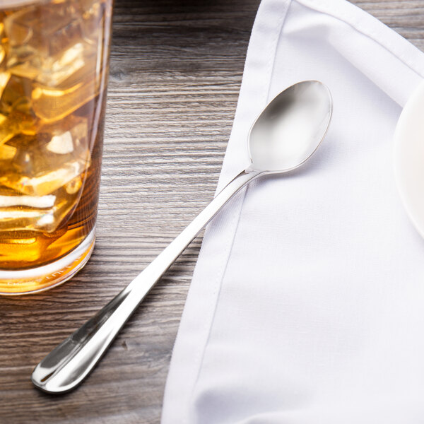 A Walco Lancer iced teaspoon next to a glass of ice.