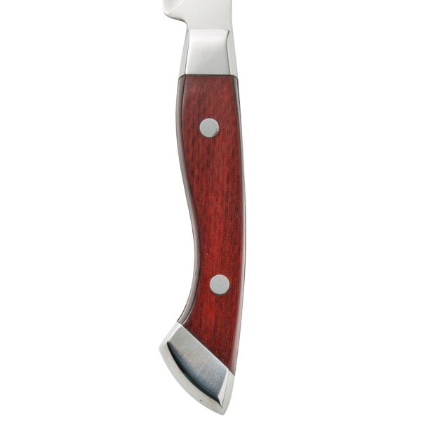 A Walco stainless steel steak knife with a Pakka wood handle on a wood surface.