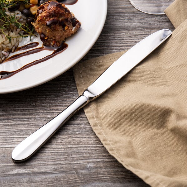 A plate of food with a Walco Lancer stainless steel dinner knife on it.