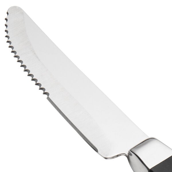 A Walco stainless steel steak knife with a black Delrin handle.