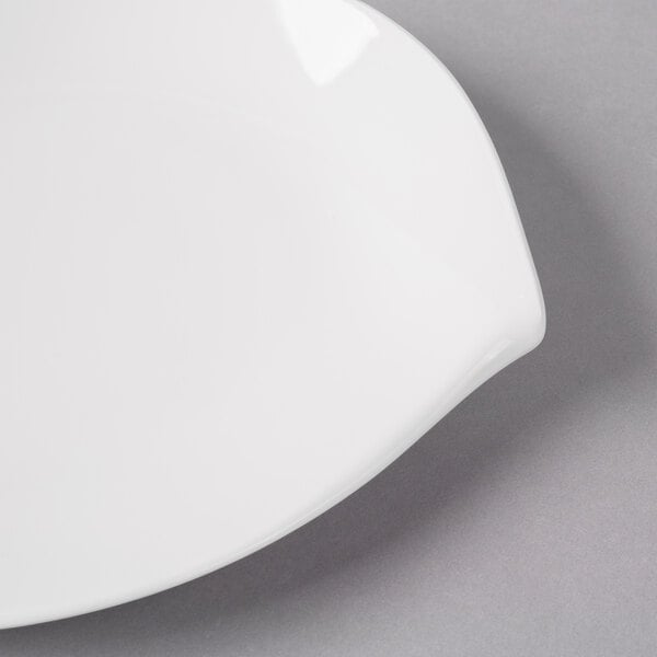 A Villeroy & Boch Flow white porcelain flat plate with a white rim on a gray surface.