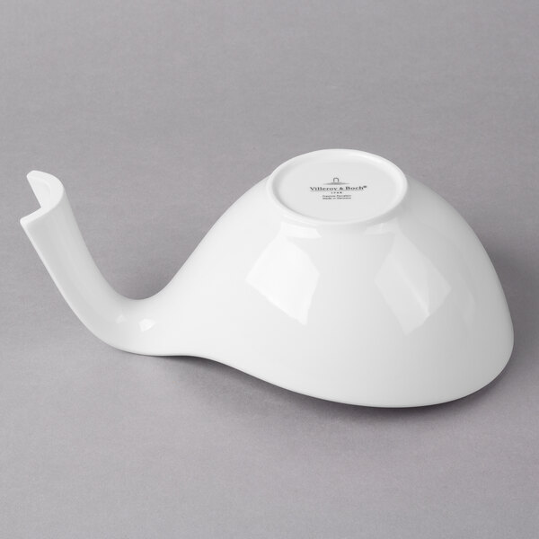 A white porcelain bowl with a handle.