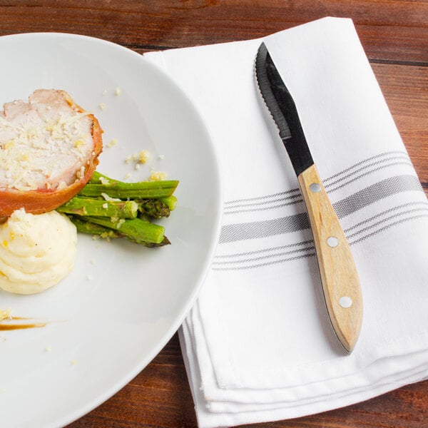 A plate of food with a Walco steak knife and fork on it.