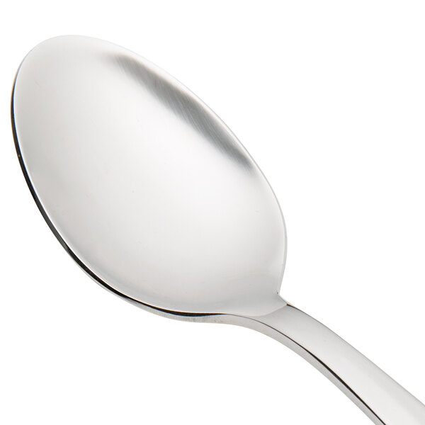 A close up of a Walco stainless steel teaspoon with a silver handle.