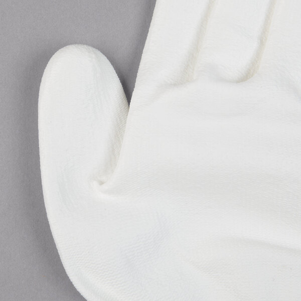 A Cordova Mirage white glove with a white palm on a gray surface.