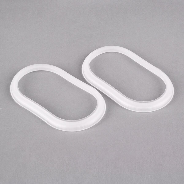 Two white oval shaped gaskets for a Crathco beverage dispenser bowl.