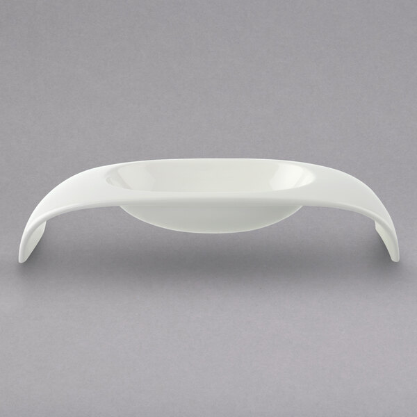 A white bowl with two curved handles.