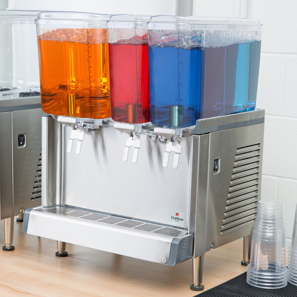 A Crathco beverage dispenser bowl assembly with three different colored drinks in it.