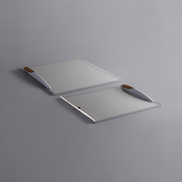 Two Avantco glass lids with metal handles on a white surface.
