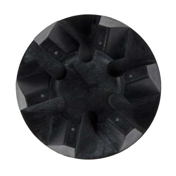 A black circular plastic drive coupling with holes.