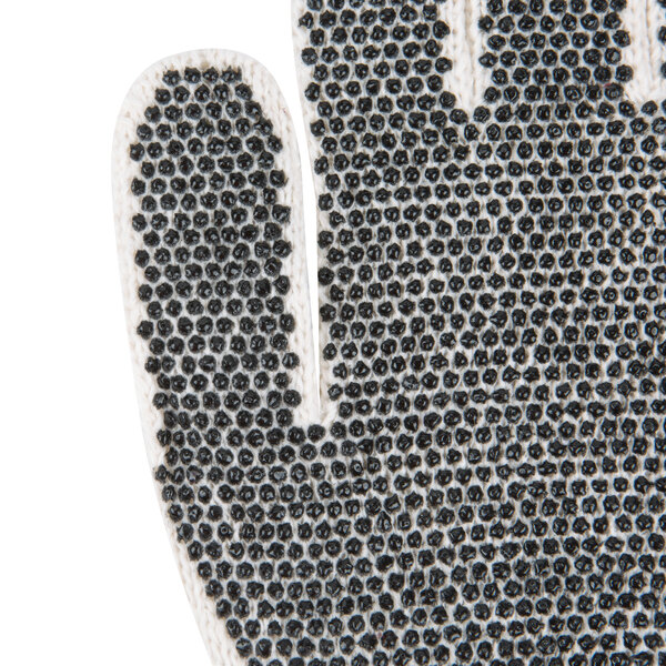 A close-up of a Cordova warehouse glove with black PVC dots on white fabric.